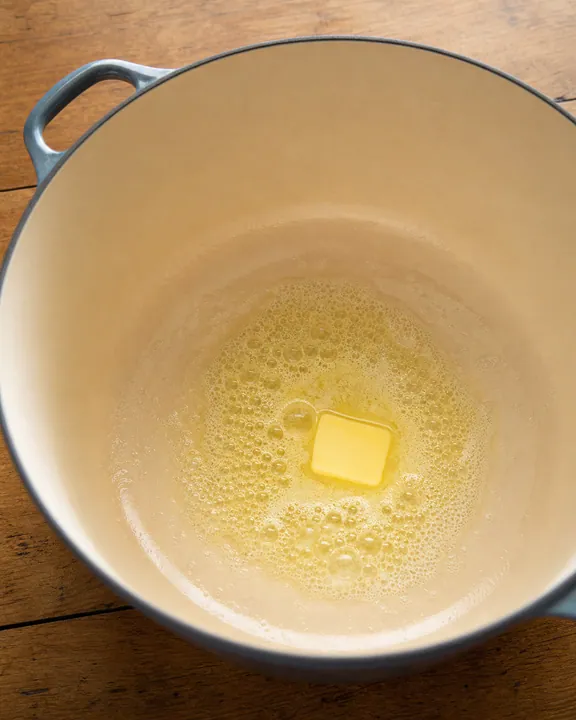 Mantequilla espumando en el fondo de una olla pesada