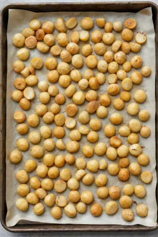 Nueces de macadamia ligeramente tostadas en una bandeja forrada