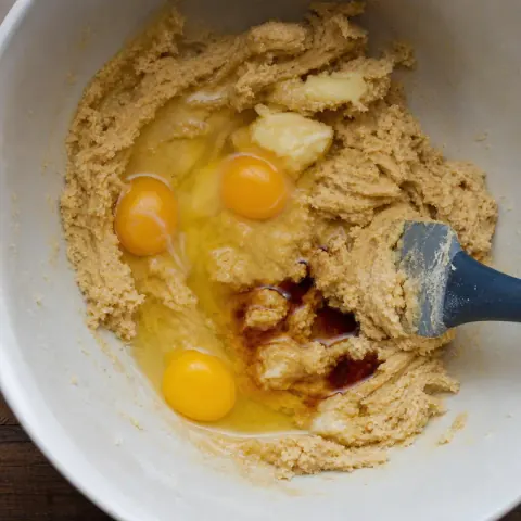 Se agregan huevos, mantequilla y vainilla a una masa espesa para galletas.