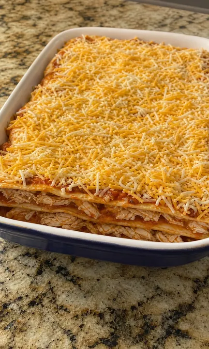 Cazuela de enchiladas sin hornear en capas con pollo, tortillas y queso