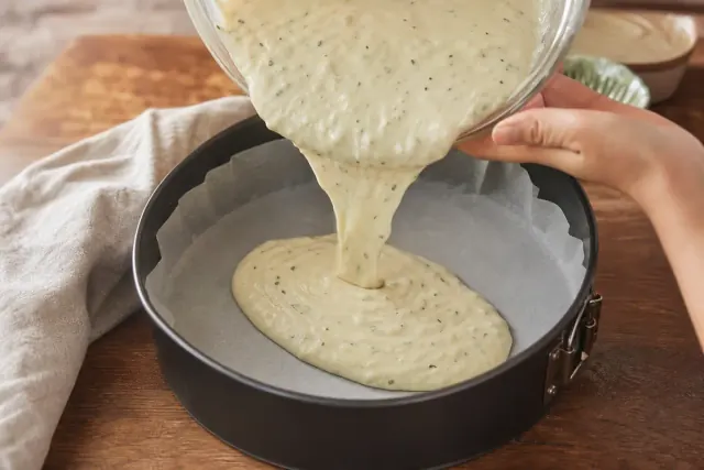Half of the savory batter poured into the lined springform pan
