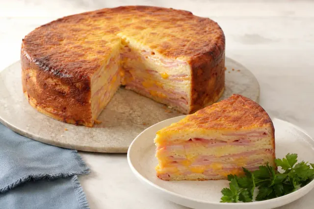 Sliced torta de fiambre showing ham and melted cheese layers