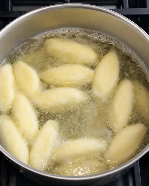 Albóndigas de sémola cociéndose en agua hirviendo