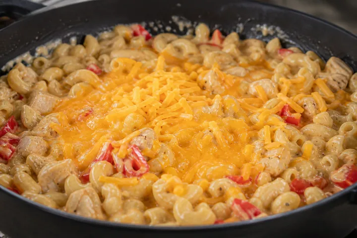 Grated cheddar melting into the macaroni