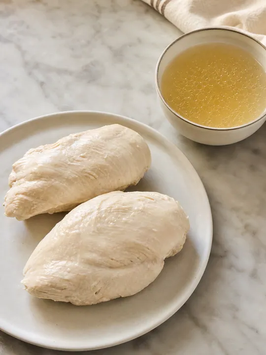 Poached chicken breasts removed with reserved broth