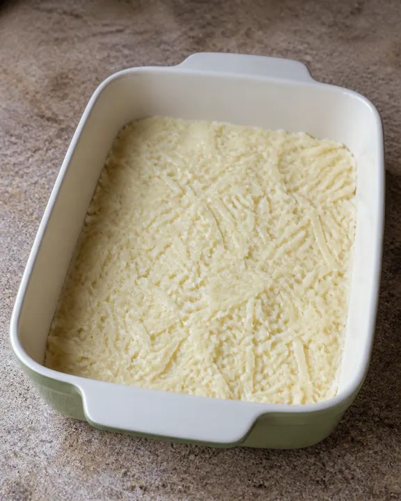 Half the potato mixture spread in the baking dish