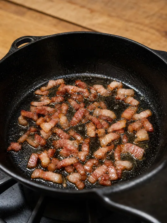 Bacon friéndose hasta quedar crujiente en una sartén