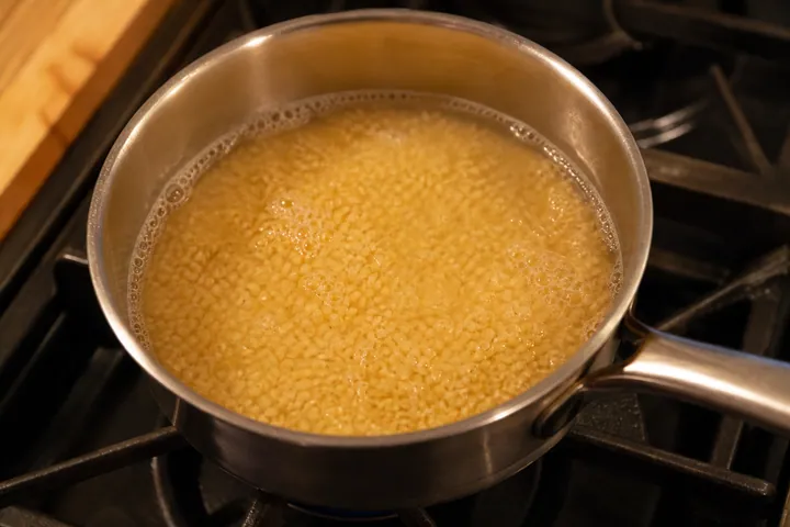 Bulgur simmering in water in a small pot