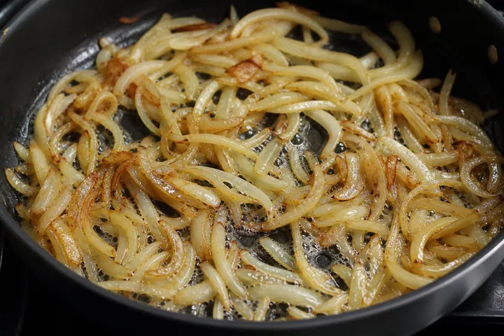 Cebolla caramelizándose en mantequilla en una sartén