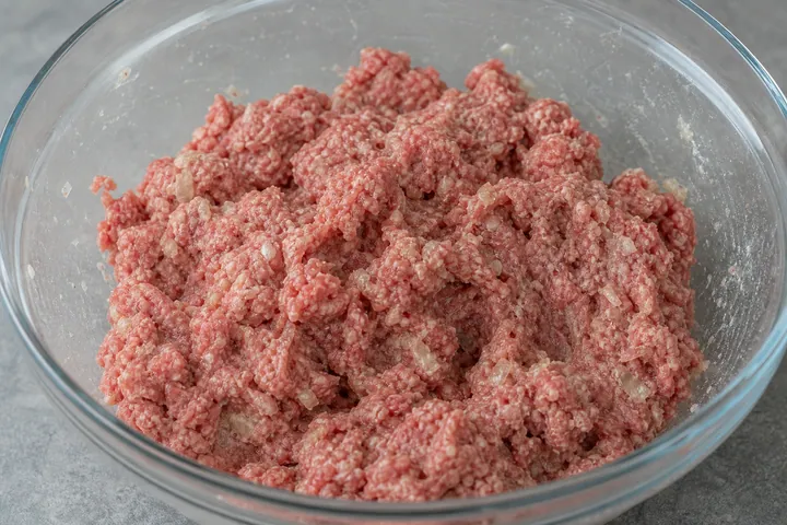 Carne picada y condimentos mezclados en un bol
