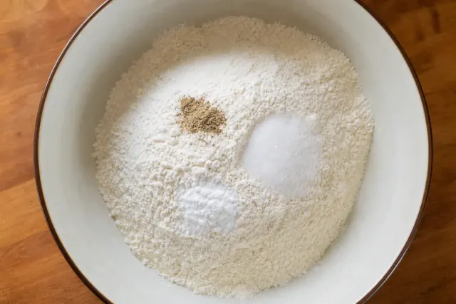 Harina, azúcar, sal, levadura en polvo y cardamomo en un bol