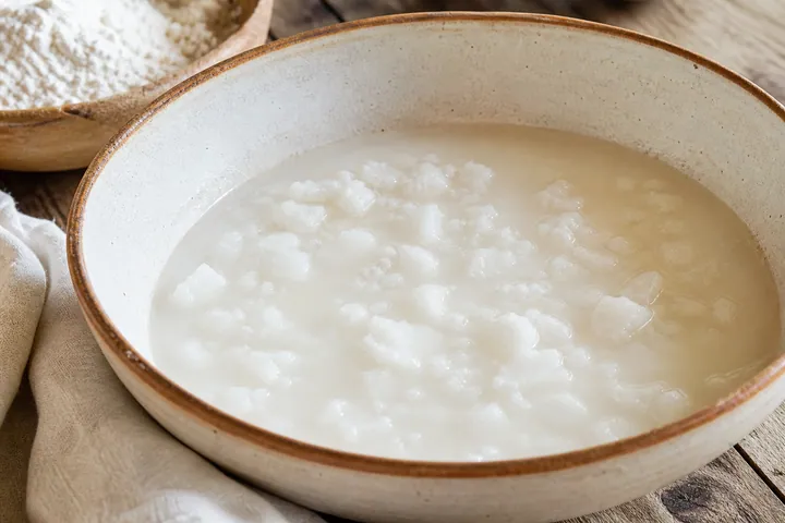Lard, warm water, and salt mixed in a dough bowl