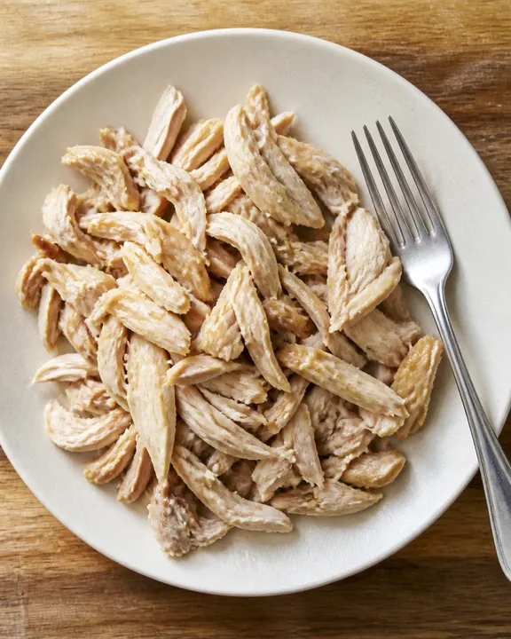 Pollo cocido desmenuzado en un plato