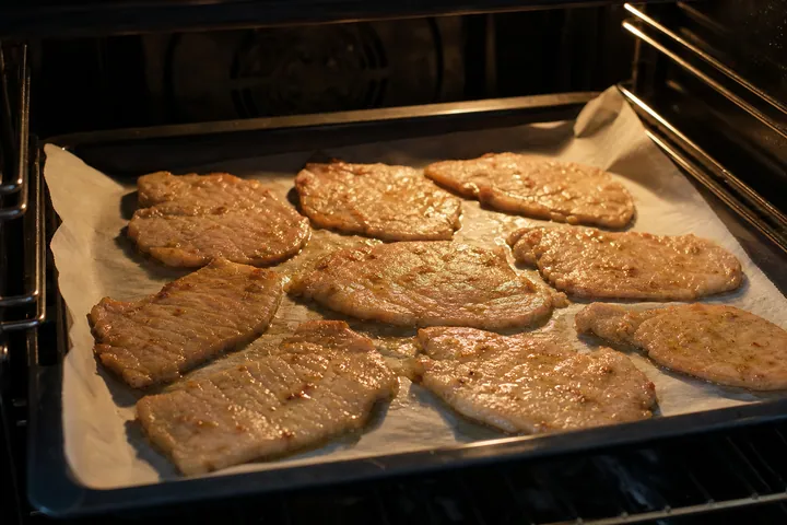 Marinated pork baking on a lined oven tray
