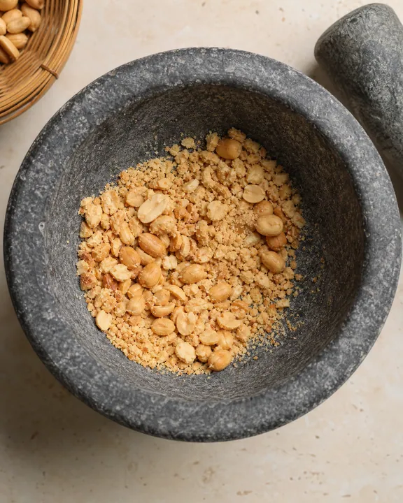 Roasted peanuts coarsely crushed in a mortar