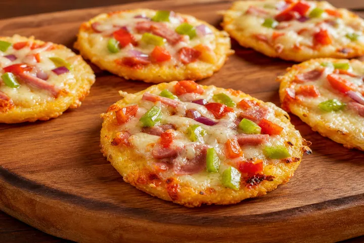 Golden cassava mini pizzas served hot on a wooden board