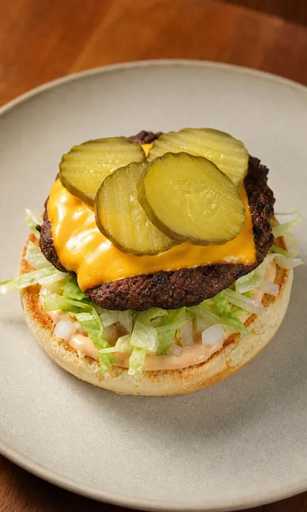 Lower burger layer with lettuce, onion, cheese, and pickles