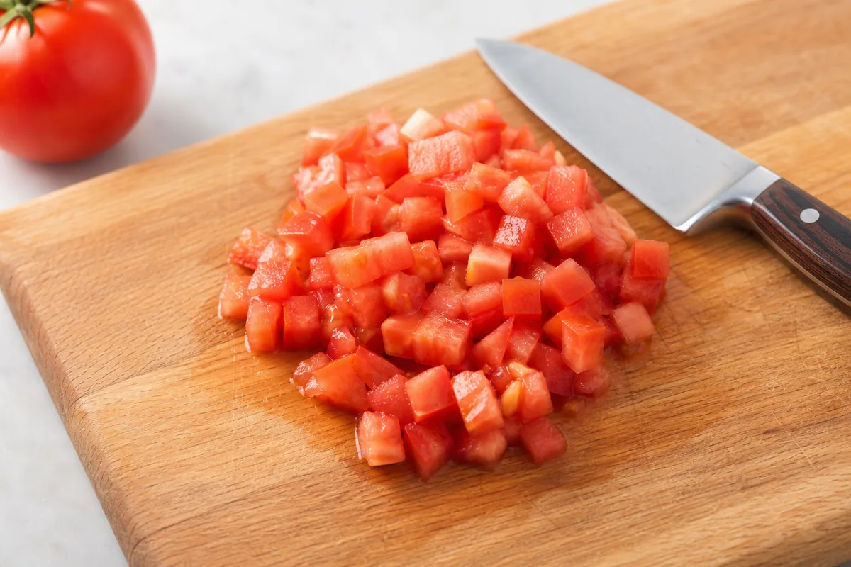Diced ripe tomato on a wooden cutting board