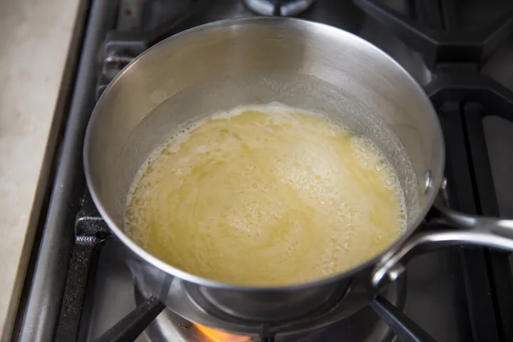 Mantequilla, azúcar y leche calentando hasta hervir en una cacerola.