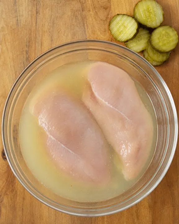 Filetes de pollo marinándose en salmuera de pepinillos