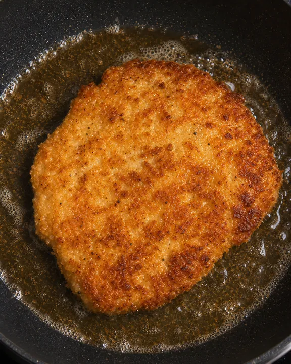 Filete de pollo rebozado friéndose hasta dorarse